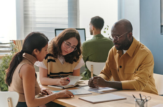Group of multiethnic business people discussing at table during meeting at office, they planning new business strategy