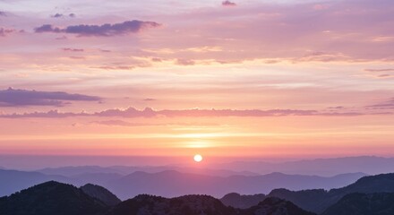 Sunset or sunrise over distant mountains with pink and purple sky.