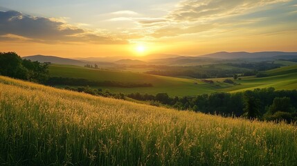 Fototapeta premium Golden sunset over rolling green hills and fields