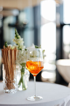 Elegant Cocktail Glass with Aperitif and Breadsticks on White Table in Sunlit Setting