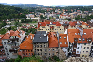 Fototapeta premium Panoramic view of Kłodzko, Poland, with colorful rooftops and historic buildings surrounded by green hills
