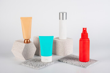 Plastic white tube for cream or lotion. Skin care or sunscreen cosmetic, Cosmetic red bottle. Womens cosmetic accessory for makeup with stylish props on white background.