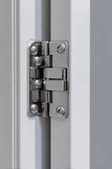 Naklejka premium Close-up of a metallic door hinge on a white door for home improvement and construction projects