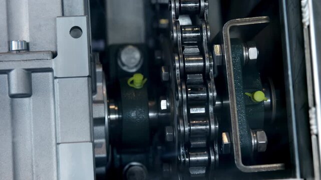 Industrial chain drive rotating inside machinery. Media