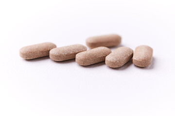 Creatine capsules on paper background. Soft focus. Close up. Copy space.	