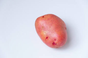 Selective focus of red potato on white background