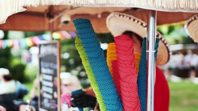 Colorful waffle cones hanging at a mexican food stall during a summer outdoor festival