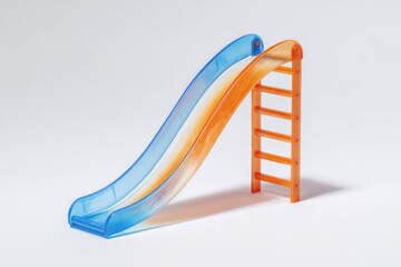 Miniature plastic slide, orange and blue, on a white background.  A small,  child's slide, with a gradient of orange and blue, angled and leaning,  is set against a bright white backdrop.