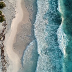 Drone shot of clean beachscape with vibrant sea foam and white sand
