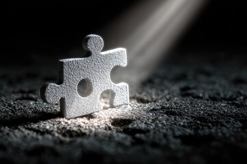 Single puzzle piece illuminated by spotlight on dark textured ground
