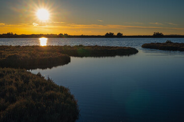autumnal sunset over the lagoon, Po river delta, Comacchio, Ferrara, Italy