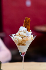 Traditionelles peruanisches Lucuma-Eis mit Schlagsahne und knuspriger Waffel, serviert im Cocktailglas