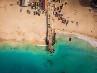 Aerial drone shot of the Santa Maria pier and beach, Sal Island, Cape Verde, at golden sunset. Turquoise waters, fishing boats and a tropical atmosphere in high resolution.
