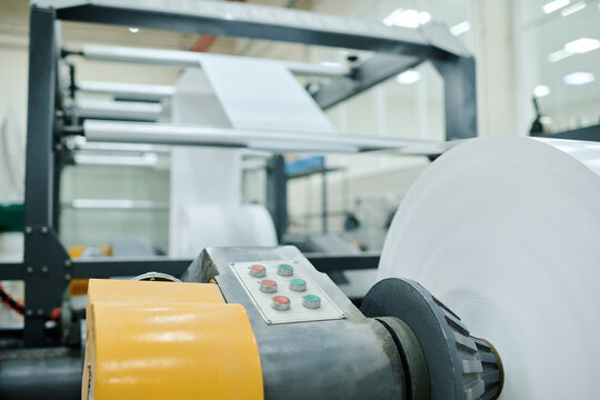 Selective focus no people shot of part of modern flexographic printing press with rolls of flexible material