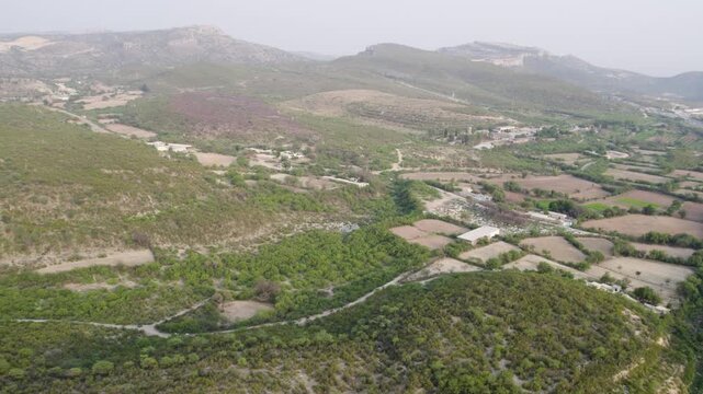 Aerial view of cultivated farmland and scattered dwellings across rolling hills in Chakwal. Punjab, Pakistan