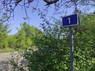 Road sign 1. First kilometer. Start of the countdown. Start of the journey. First mile. 1 mile. 1 km