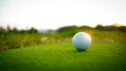Golf clubs and balls on a green lawn in a beautiful golf course with morning sunshine.