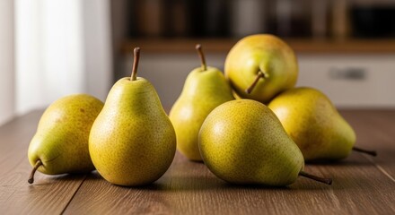 Several ripe, yellow-green pears clustered on a wooden table, soft light
