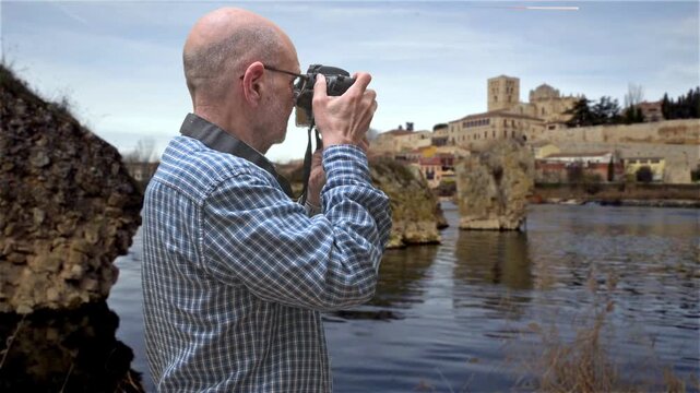 Zamora, Spain. Man Photographing Scenic River View With Historical Background Architecture