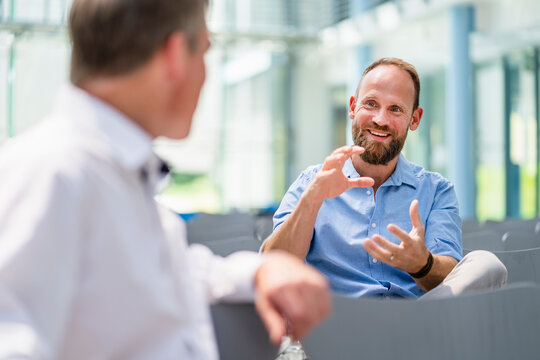 Two businessmen meeting in company auditory discussing business solutions