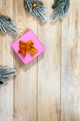 Snowy Christmas fir branches, sparkling ornaments, and festive gift on cozy rustic wooden table