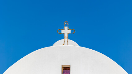 Traditional White Greek Orthodox Church Dome with Golden Cross Against Clear Blue Mediterranean Sky