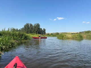 Kayaking adventure in the Nida Valley, surrounded by lush greenery and calm river waters. The photo...