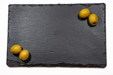 cuatro oliva rellena de anchoas dos en cada esquina sobre un plato de pizarra negra