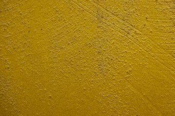 close-up shot of a textured gold yellow concrete surface. The rough and slightly uneven texture, along with subtle variations in the gold yellow hue, creates a visually interesting background.