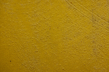 close-up shot of a textured gold yellow concrete surface. The rough and slightly uneven texture, along with subtle variations in the gold yellow hue, creates a visually interesting background.
