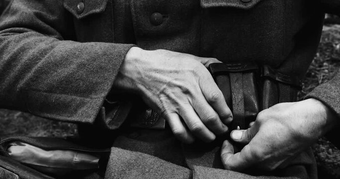 Historical Re-enactment Black And White Video. World War II German Soldier Preparing His Ammunition - Rifle cartridge. Soldier Preparing Weapon. German Military Ammunition Of A German WW2 Soldier
