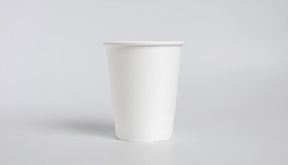 A simple blank white paper cup isolated on a light gray background, perfect as a clean mockup for branding and design concepts.