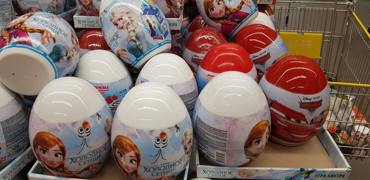 A close-up of a shop window or product display. In the foreground are large plastic eggs with images of Disney and Pixar characters.  