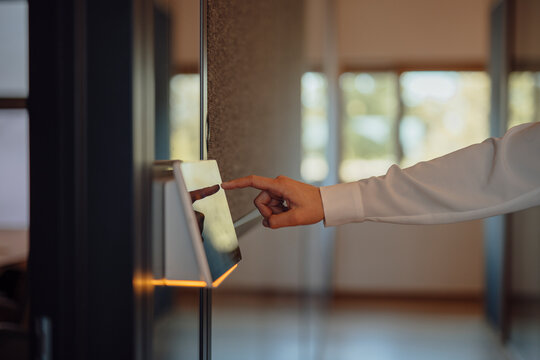 Businesswoman using touch screen control panel in modern office
