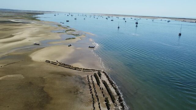 Ria Formosa riverbed with shellfish production and yachts anchored in the river