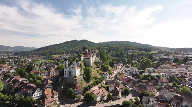 Aarburg Castle and white church above Aare river in Canton Solothurn, Switzerland, drone view on sunny summer day.