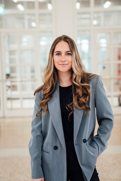 Confident businesswoman in blazer standing in modern office
