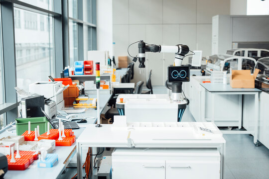 Robotic arm performing research in modern medical laboratory clean room