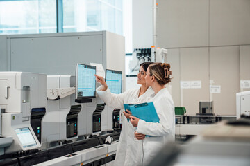 Scientists analyzing data on monitors in modern medical laboratory