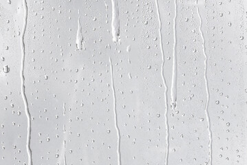 Drops of water flow down the glass leaving streaks behind. Texture for design and graphics © Elena