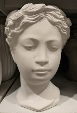 Escultura de cabeza de mujer en estante de comercio