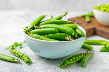 Fresh green pea pods with green peas on a wooden background. Sweet green peas. Green pea beans vegetables. Vegan. healthy vegetable. Copy space