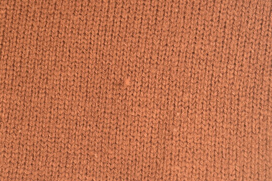 Textura de croch&ecirc; com l&atilde; marrom, tecido macio com fios de l&atilde; natural em tom quente, fundo de roupa de fios delicados vista de perto