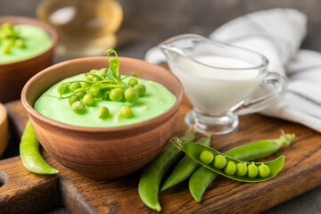 Green pea soup on a wooden table. Fresh pea soup bowl. Delicious healthy cream soup in a bowl with green peas and croutons. Healthy vegan puree. Copy space. Space for text.