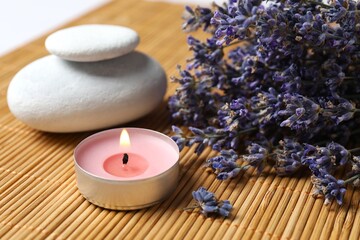 Aroma candle and lavender flowers on gray table, closeup