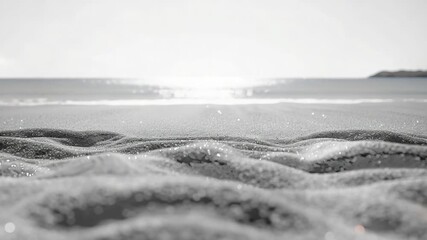 A serene black and white image of a peaceful beach scene with minimalistic waves and shore