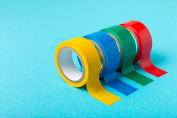 Insulating tape on a bright colored background. Set of different colors insulating tape. Reel...