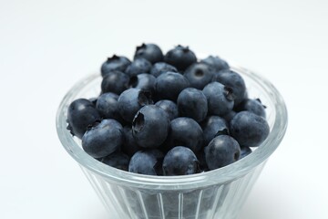 Raw organic blueberries in a glass bowl, side view.