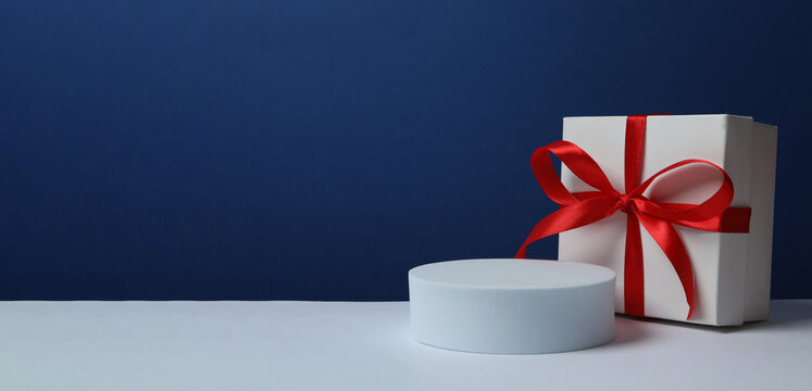 White podium with gift box on two tone background, banner, space for text