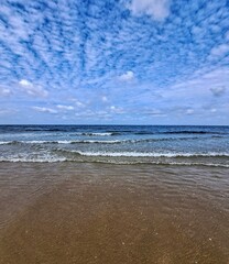 beach and sea. Sea transparent waves, horizon and blue sky with white light clouds in summer clear weather.